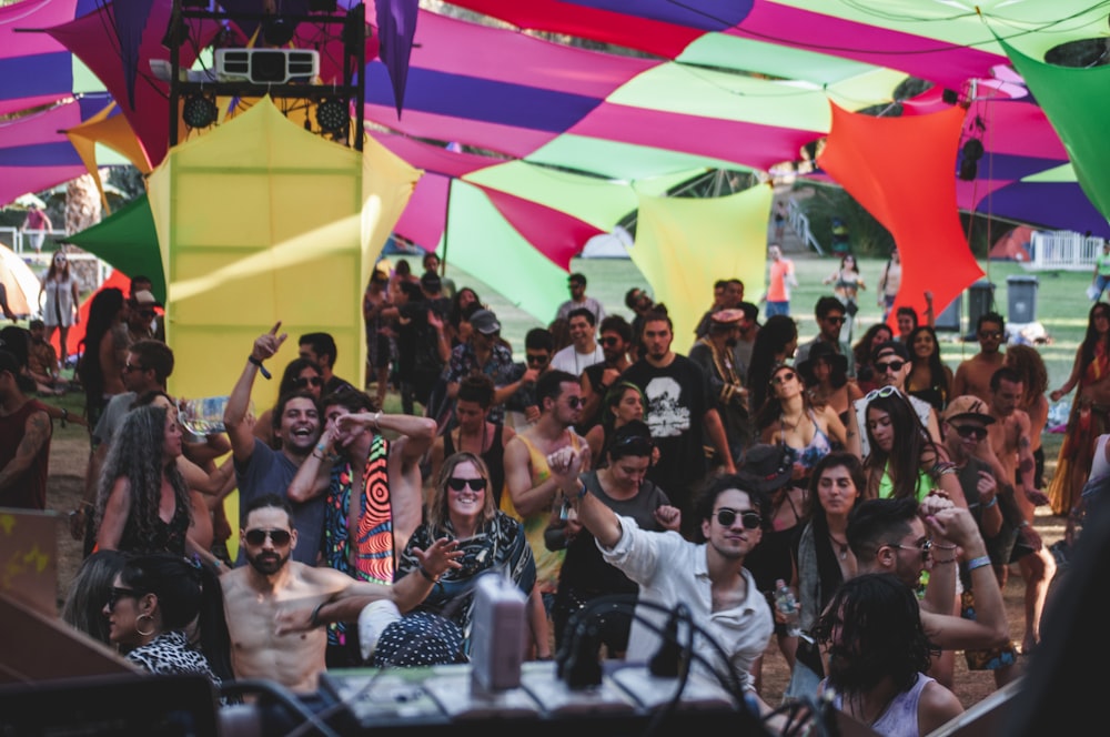 people partying under multicolored banners during daytime