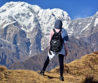 person carrying black backpack across white mountain