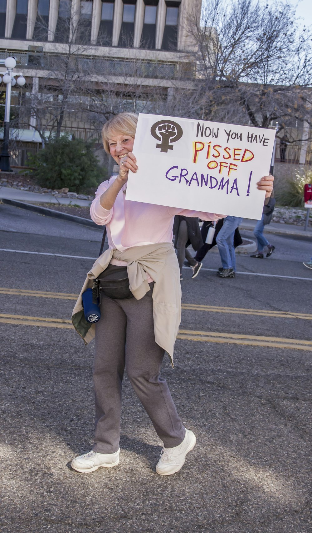 woman walking while holding now you have pissed off grandma! sign