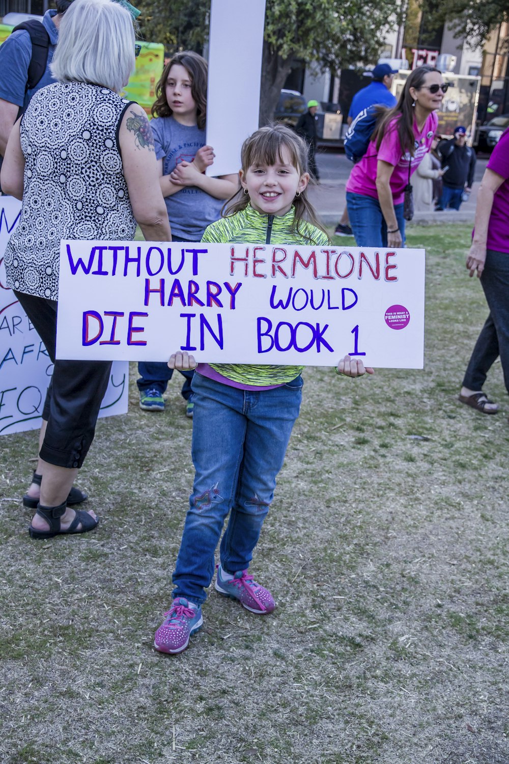 chica de pie mientras sostiene sin Hermione Harry moriría en el letrero del libro 1