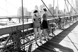 two women standing on bridge
