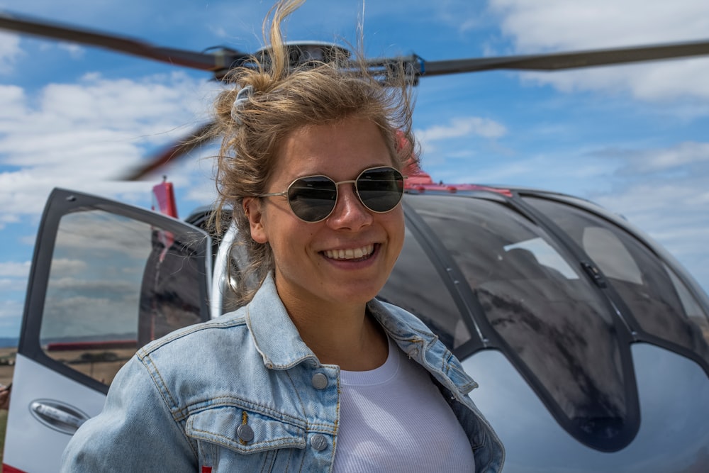 woman smiling in front of helicopter
