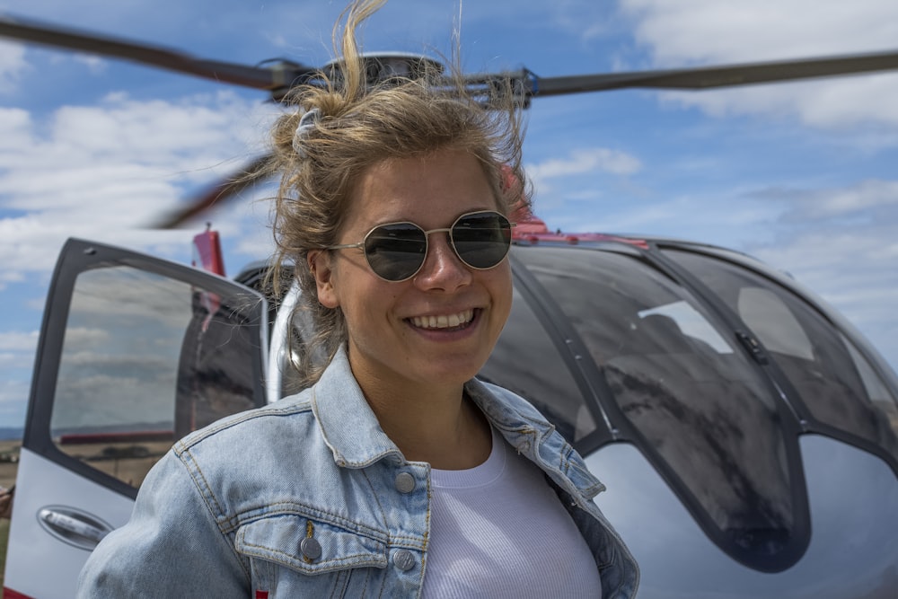 femme souriant devant l’hélicoptère