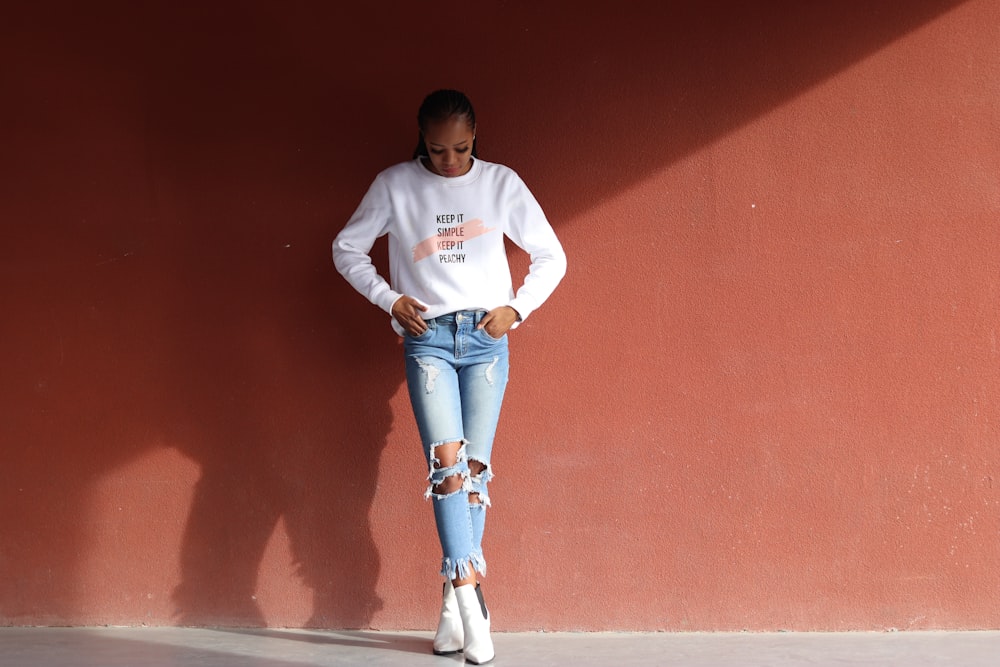 woman crossing her legs while standing and looking downwards