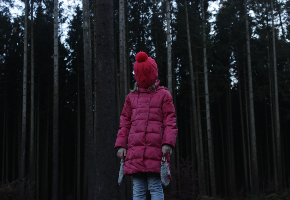 person in pink coat standing near trees