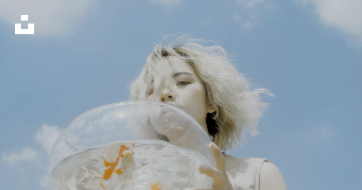 Woman Holding Round Clear Glass Fishbowl With Live Fish Under White And woman-holding-round-clear-glass-fishbowl-with-live-fish-under-white-and
