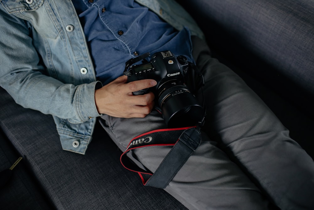 man holding camera lying on bed