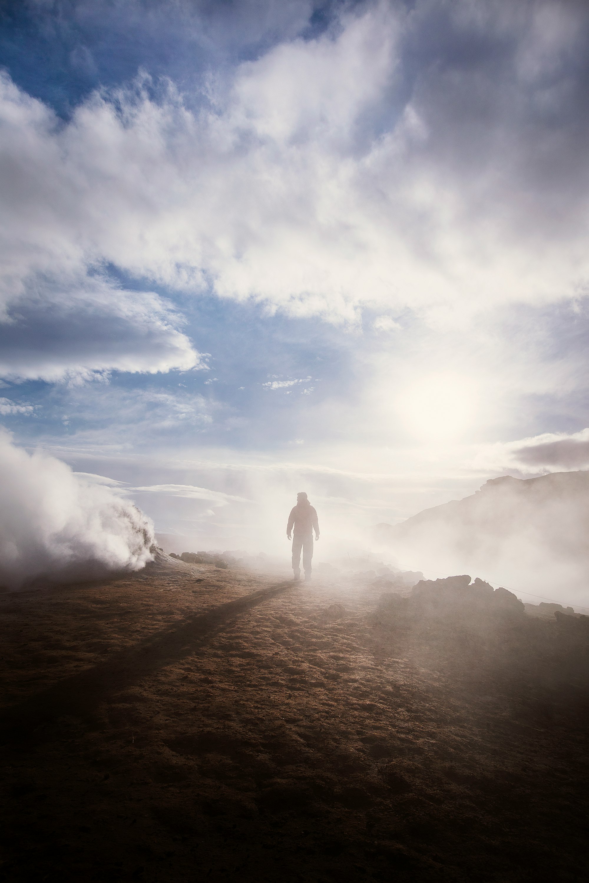 person standing near the edge of a mountain near clouds during day