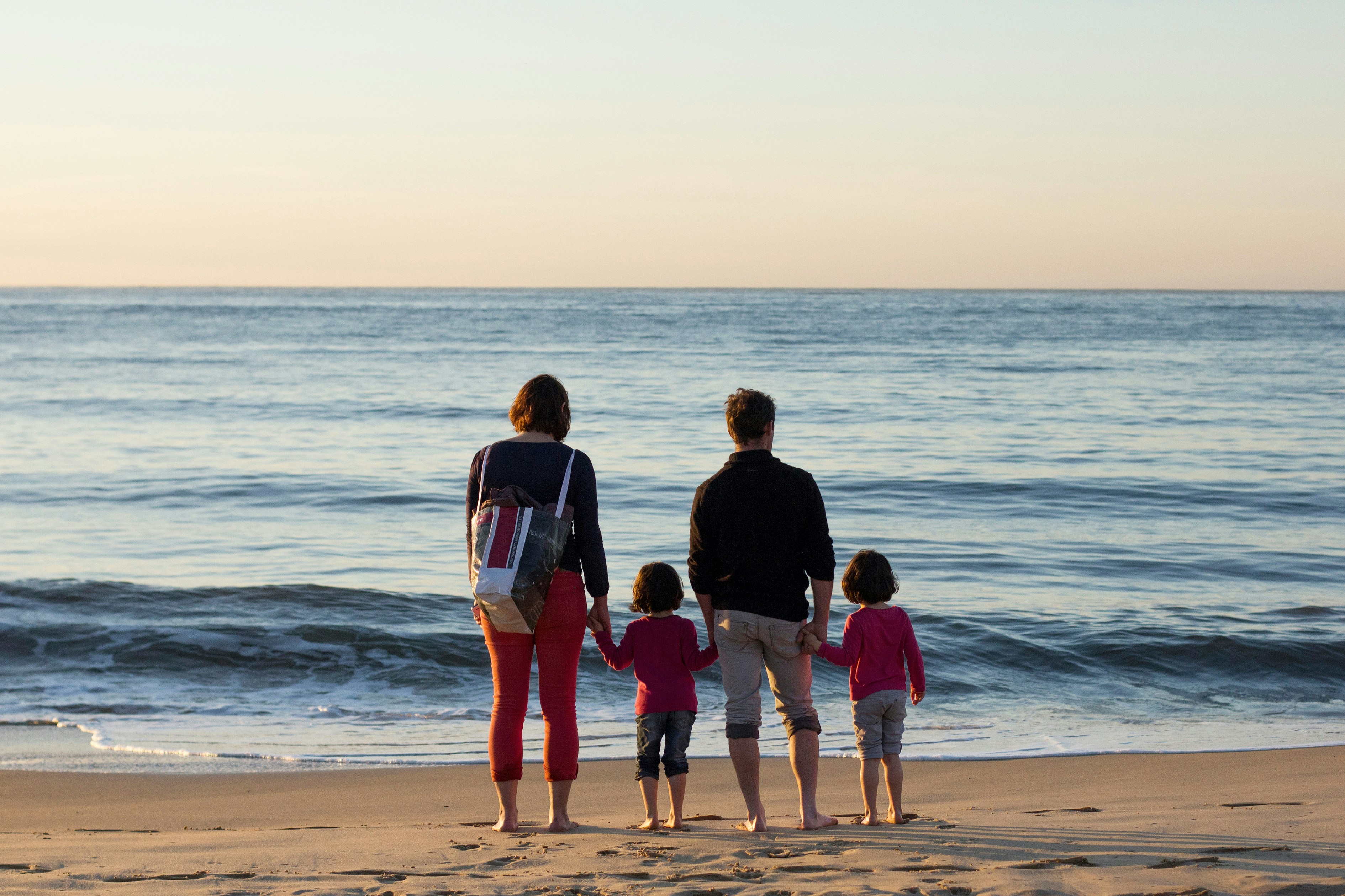 family of four standing at the seashore, 