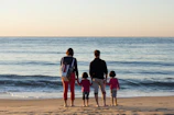 family of four standing at the seashore