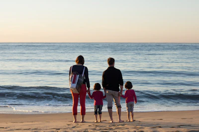 family of four standing at the seashore