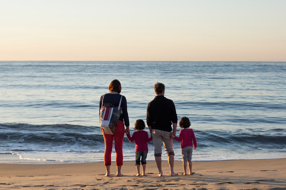 family of four standing at the seashore