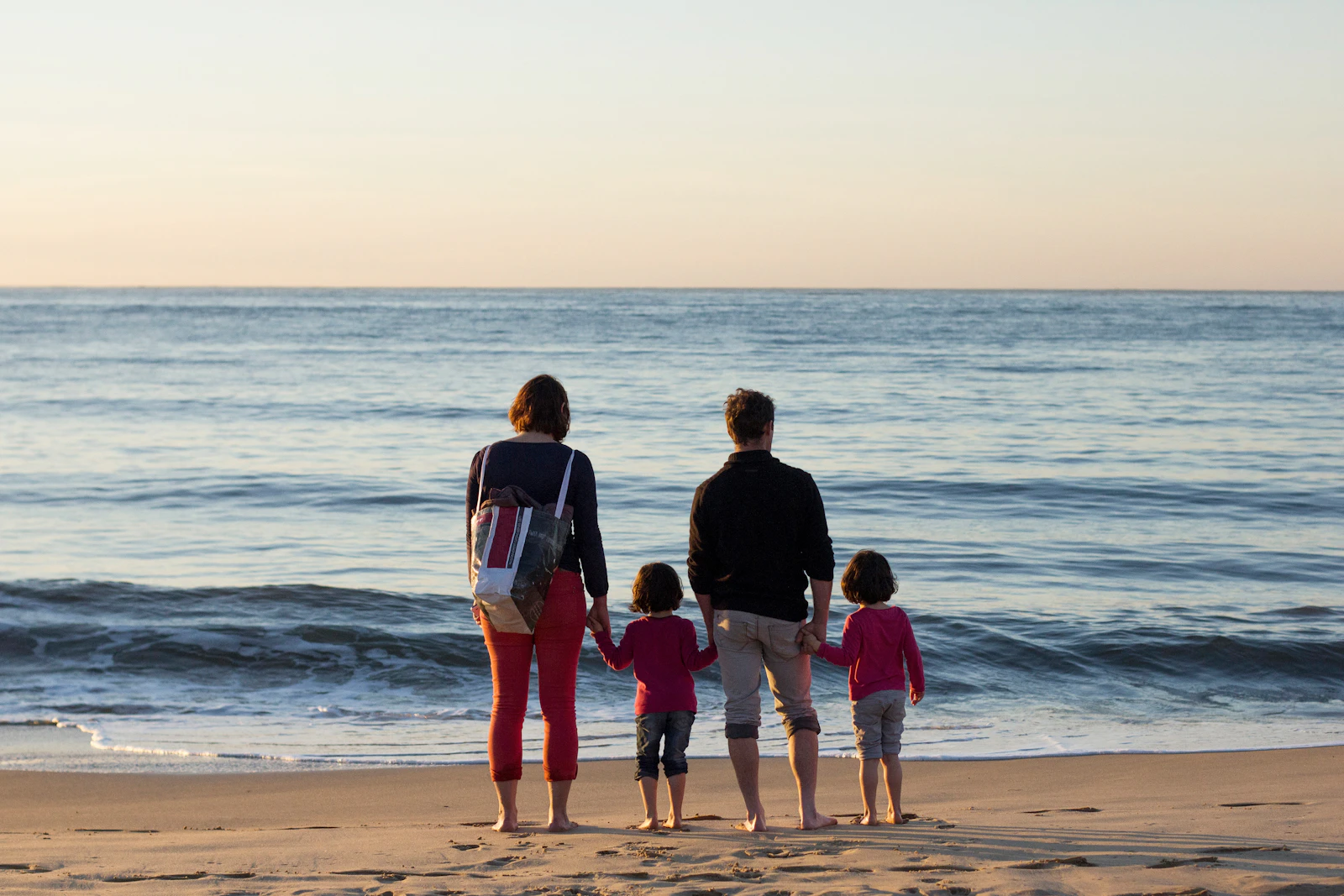 Family of four standing together at the seashore