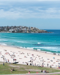 people on white sand beach at daytime
