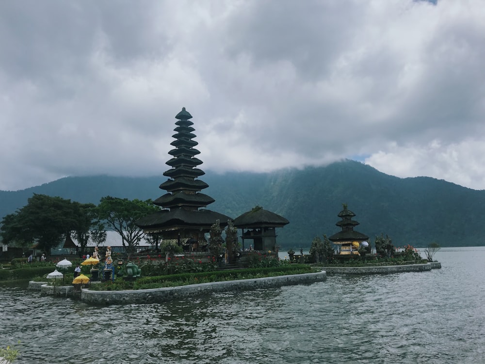 black pagoda temple by the lake under grey cloudy sky