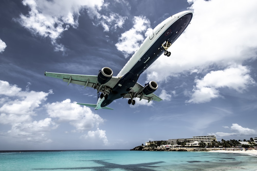 white aircraft above beach shoreline at daytime