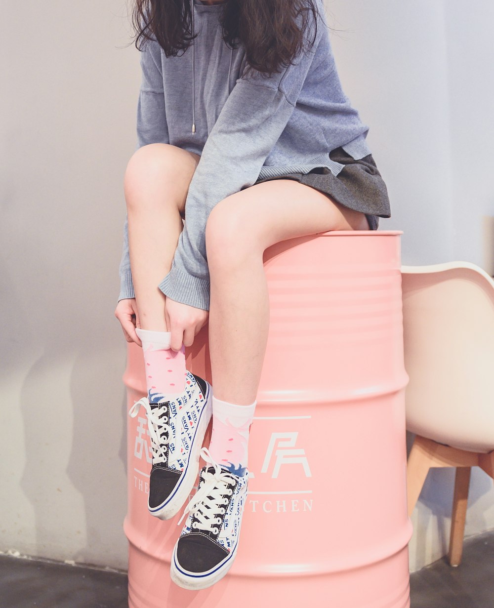 woman sitting on metal barrel