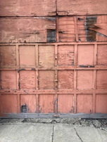 A worn-out wooden door with peeling paint before restoration.