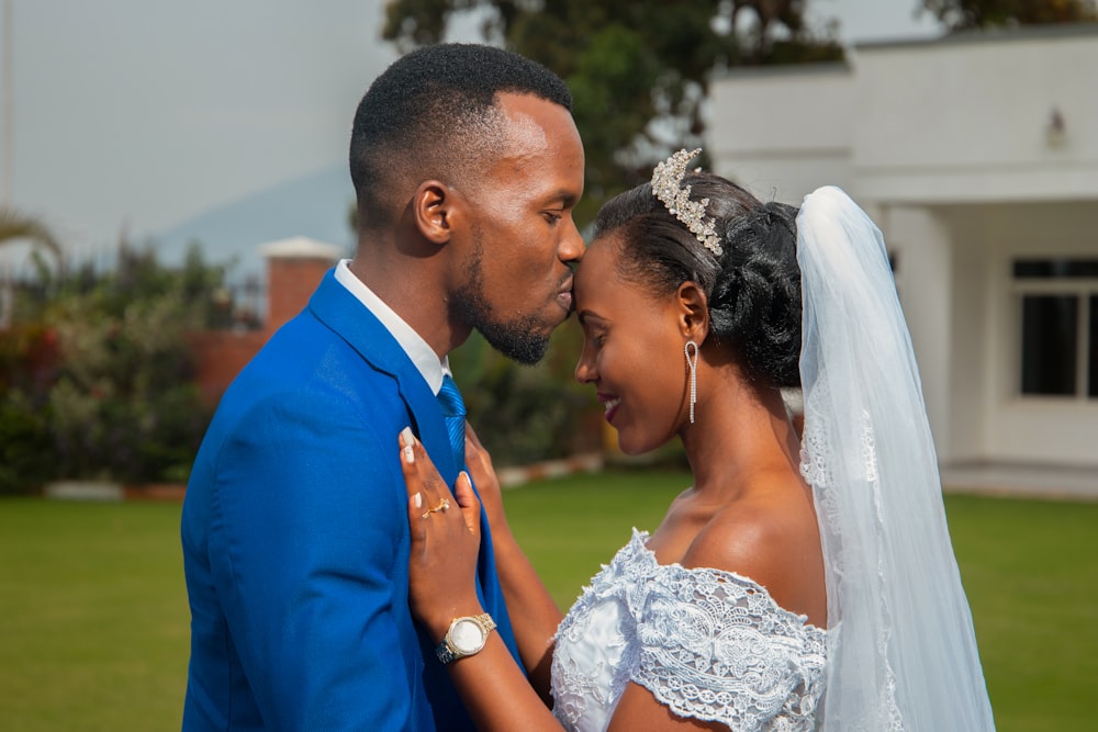 man kissing woman in forehead