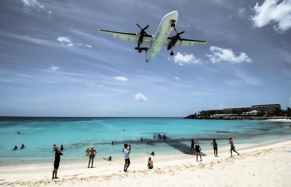 plane flying over seashore during daytime