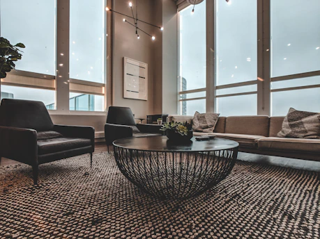 A sleek, modern living room with matte black accents and champagne gold details, bathed in natural light.