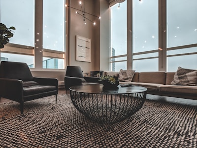 A sleek modern black and gold-themed living room with large windows and elegant furnishings.