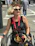 A smiling woman in adaptive clothing sitting confidently in her wheelchair outdoors.