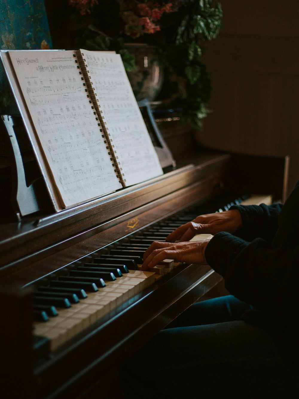 man playing the piano in front of open music book