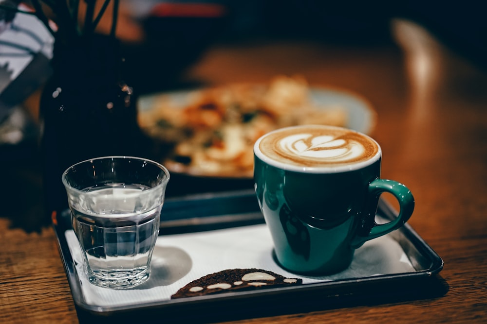 clear drinking glass and green ceramic mug