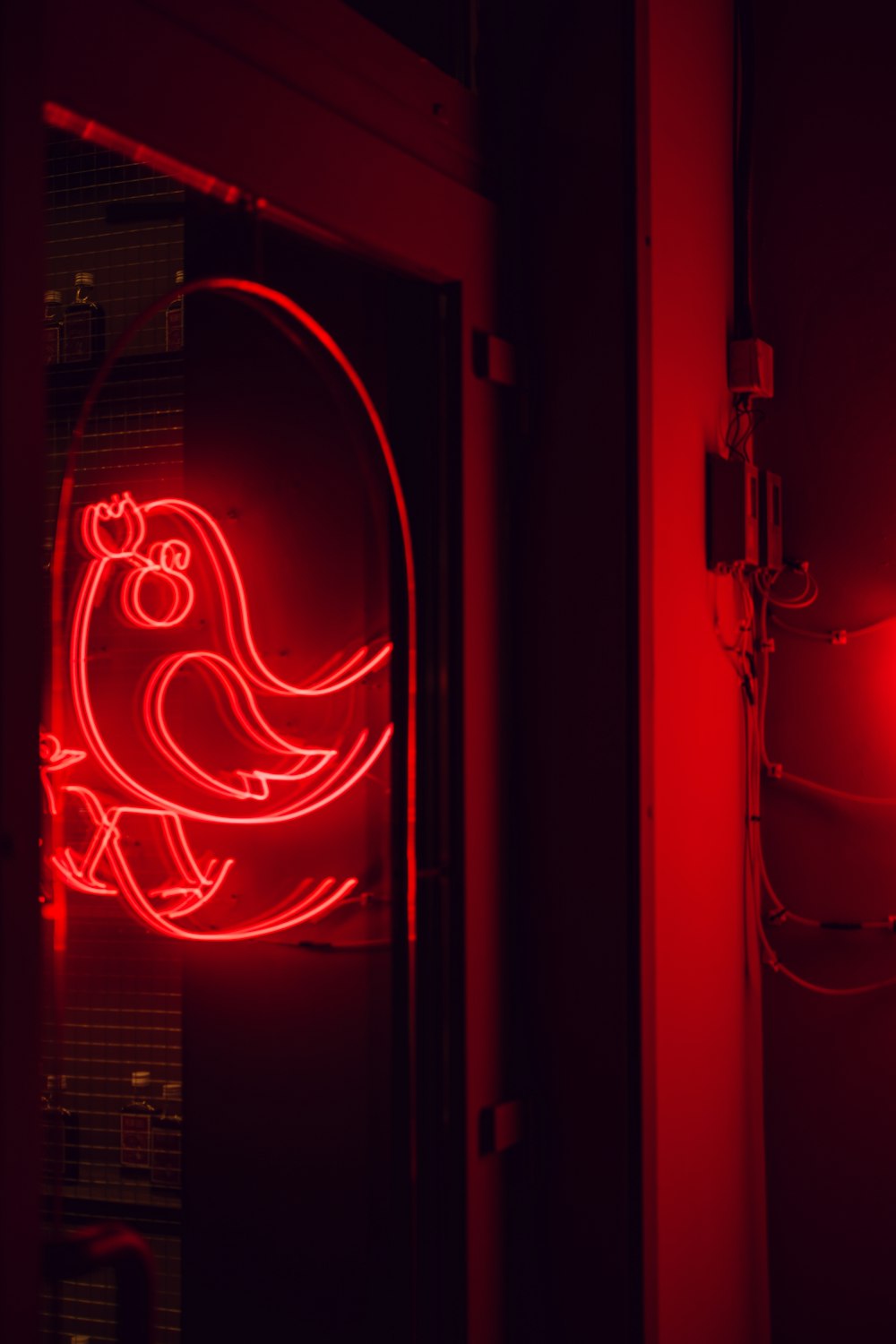a red neon sign with a bird on it