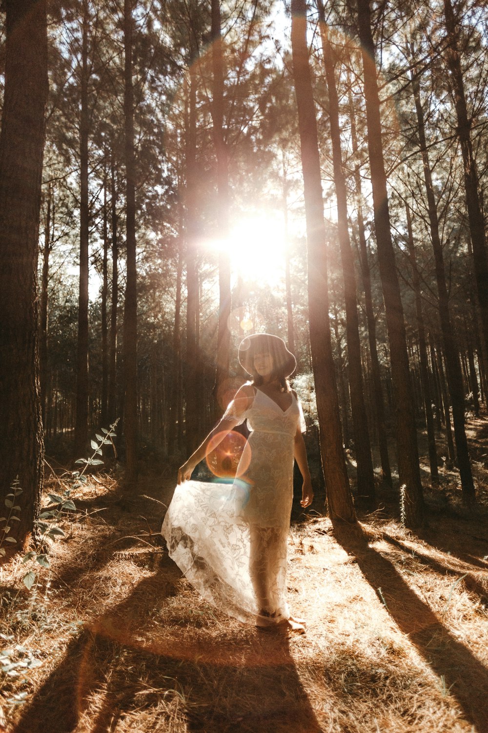 woman standing under tall trees