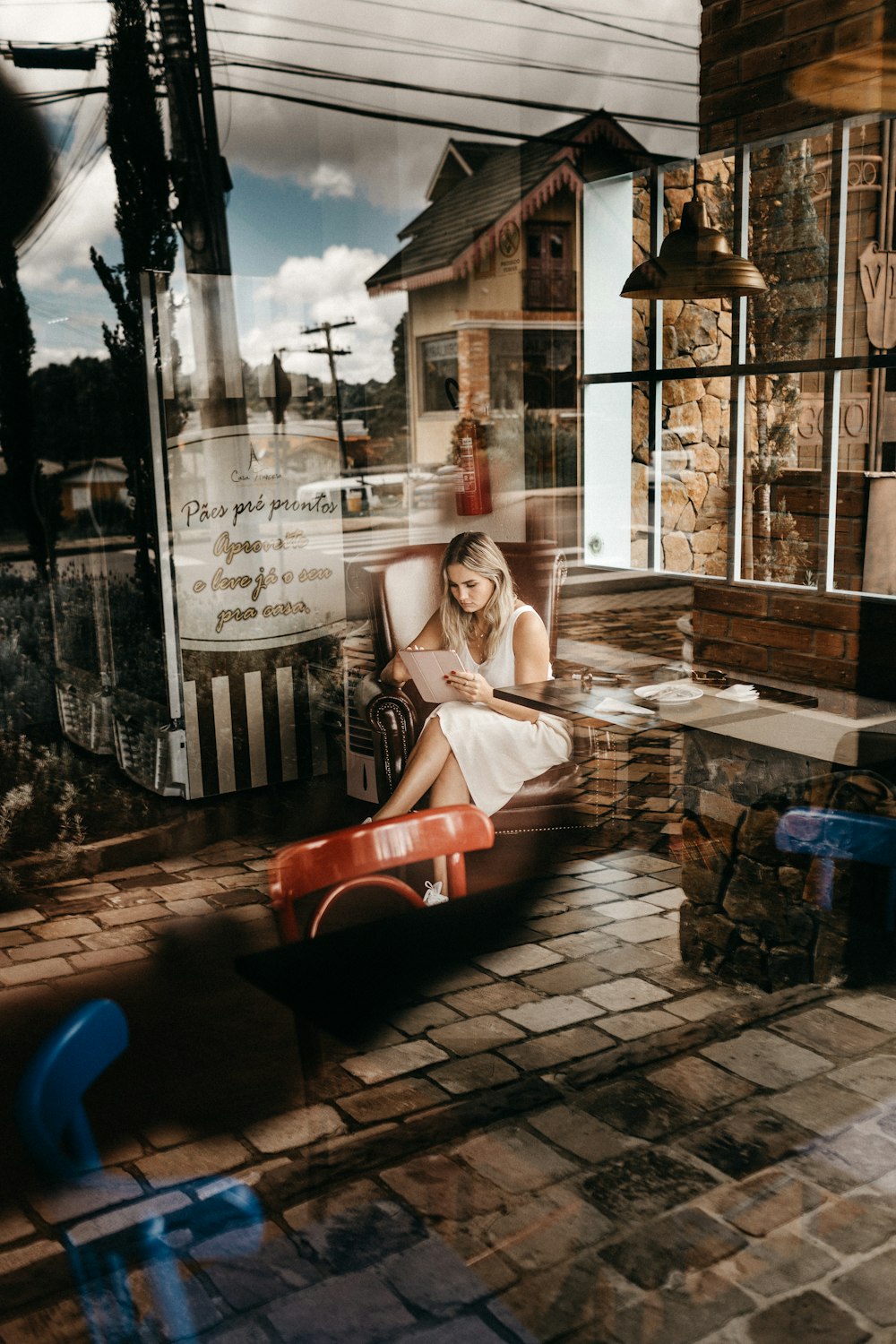 woman sitting on chair while reading book