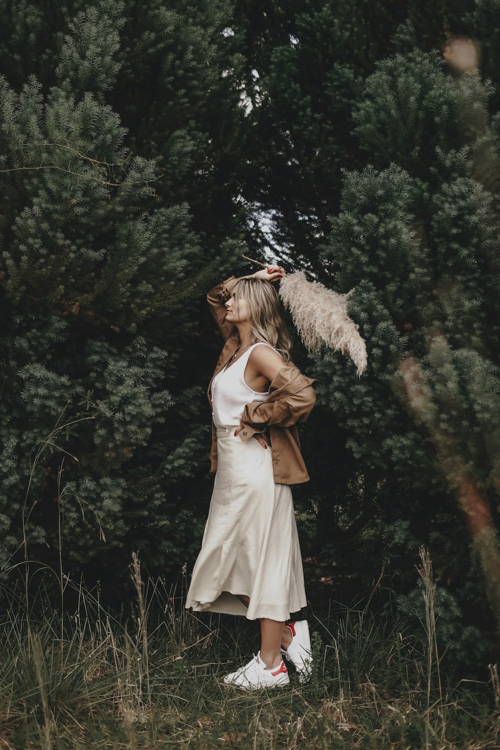 woman wearing white dress standing beside tree