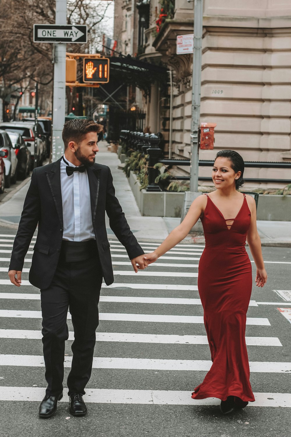 man and woman crossing the street at the pedestrian lane