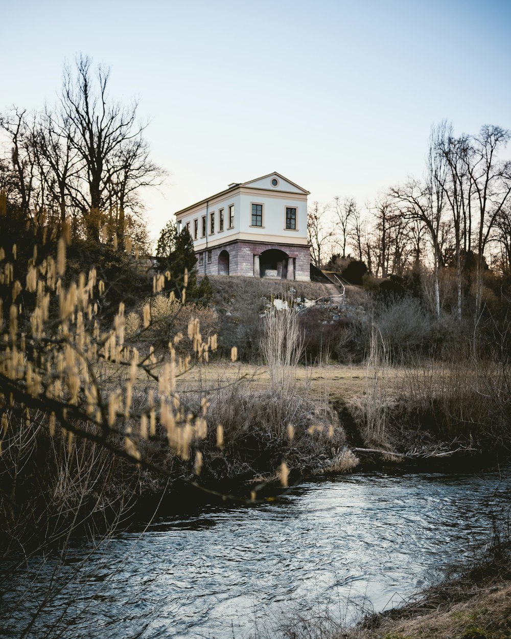 body of water near white and brown house