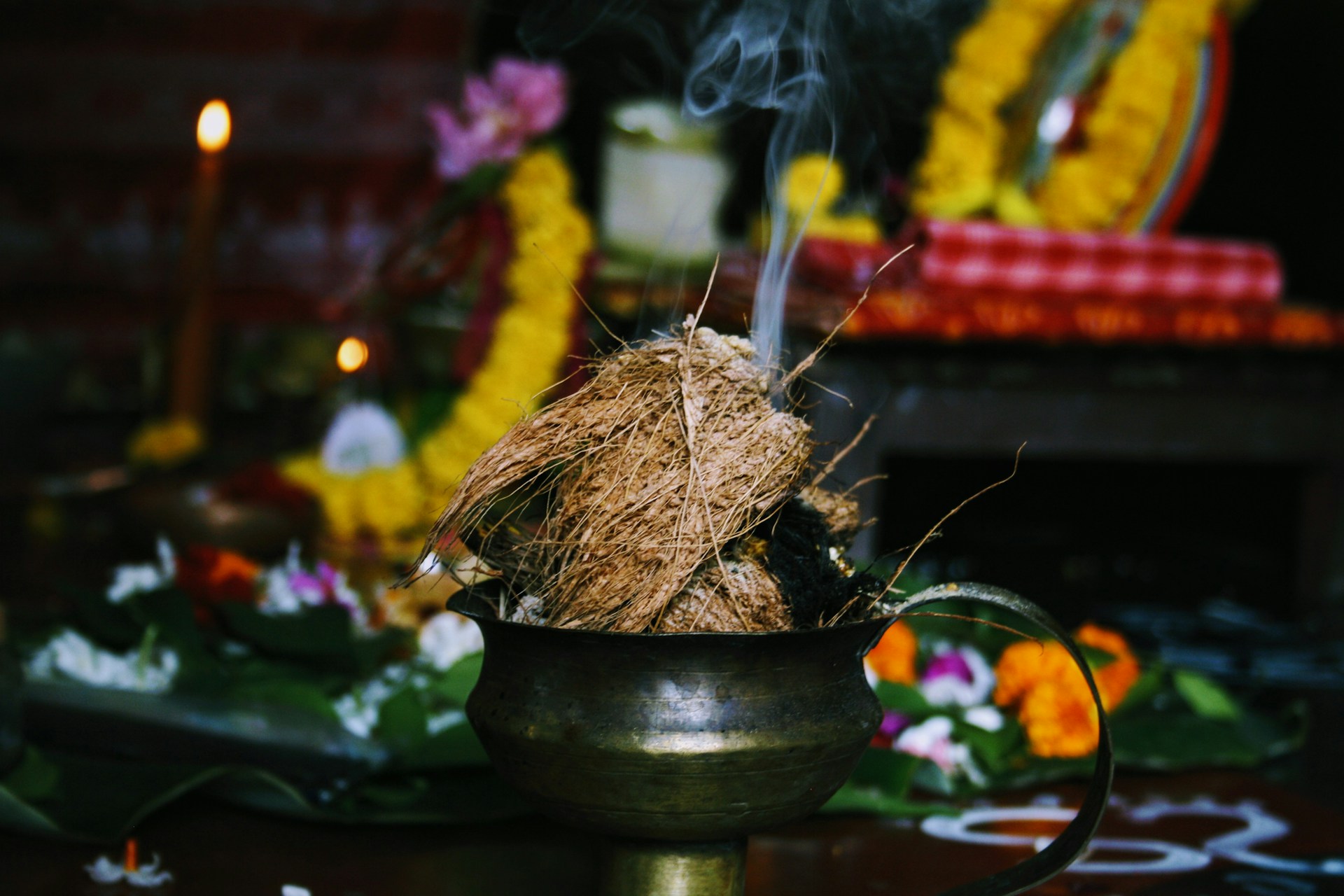 burning coconut husk on brass-colored pot