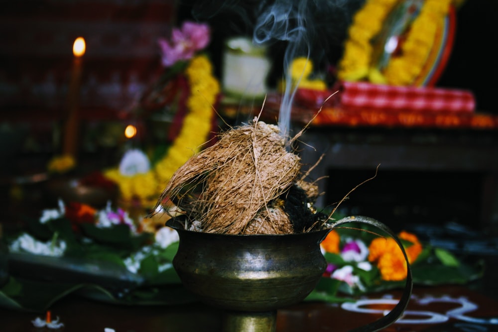 burning coconut husk on brass-colored pot
