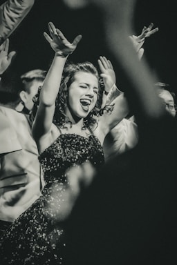 dance photography,how to photograph (internation women’s day) this young lady was all in for her high school show choir event.  i love the energy and the willingness to just throw herself into the performance 100%.  
 the show lights ended up giving this a 1940’s newspaper vibe - which i totally loved and thought made a perfect fit.; woman raising her hands