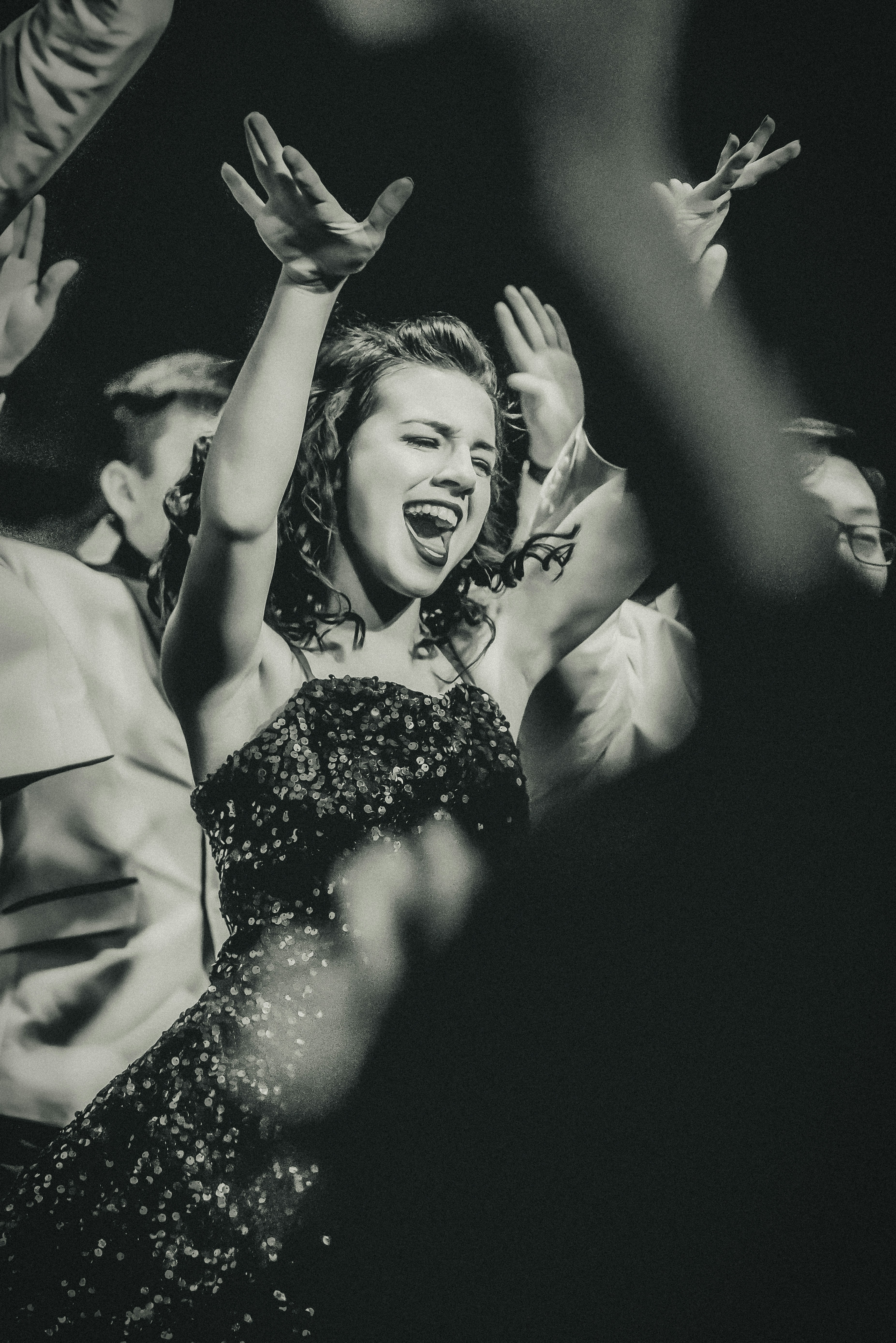 great photo recipe,how to photograph (internation women’s day) this young lady was all in for her high school show choir event.  i love the energy and the willingness to just throw herself into the performance 100%.  
 the show lights ended up giving this a 1940’s newspaper vibe - which i totally loved and thought made a perfect fit.; woman raising her hands