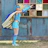 A charismatic superhero posing proudly with excited children against a bright blue backdrop.