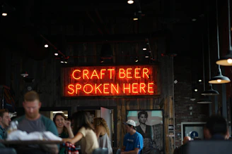 Sunlit cozy brewery corner with friends sharing craft beer and laughter.