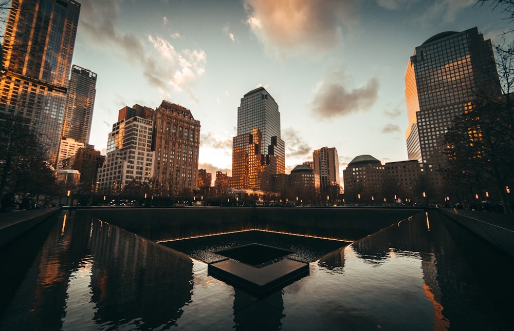 body of water near high rise buildings during golden hour