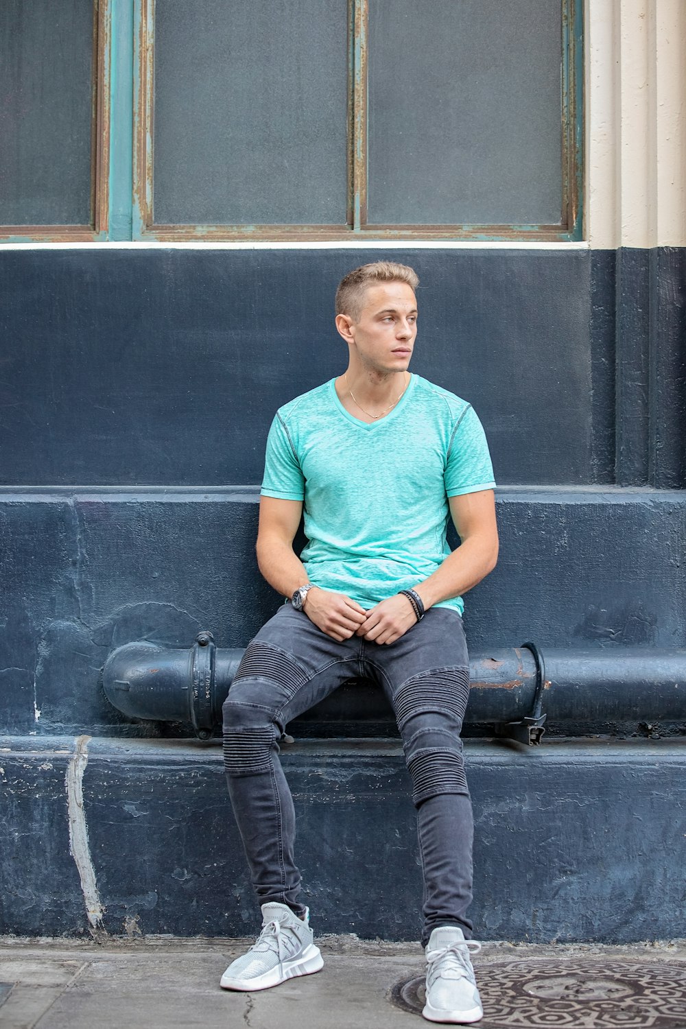 man sitting on black pipe during daytime