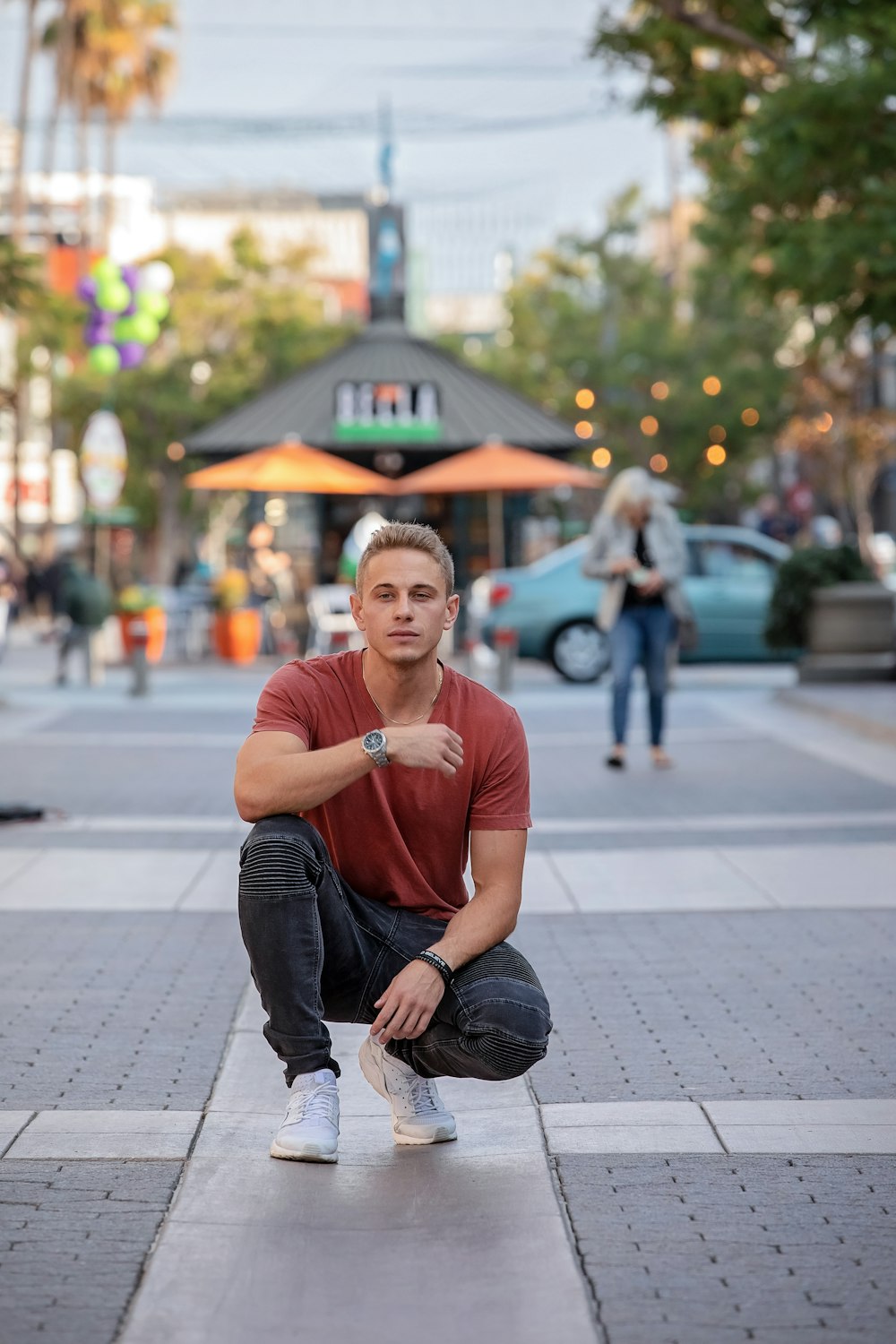 man sitting on concrete way at daytime