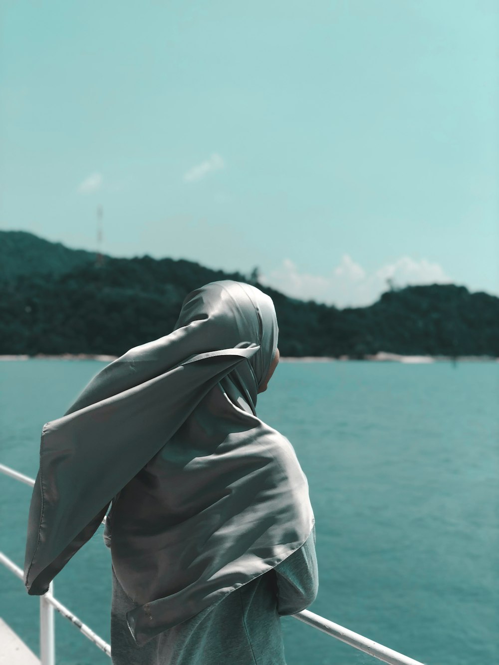 Mujer de pie en el barco cerca del cuerpo de agua durante el día