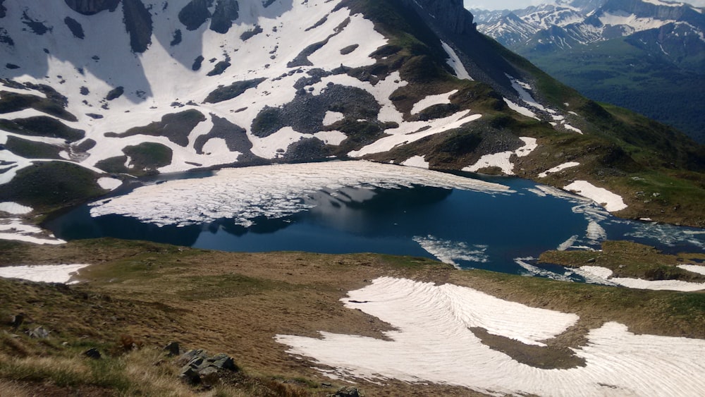 a snow covered mountain with a lake in the middle