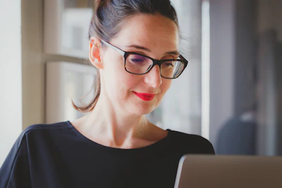A beauty clinic manager reviewing detailed performance reports on a laptop.