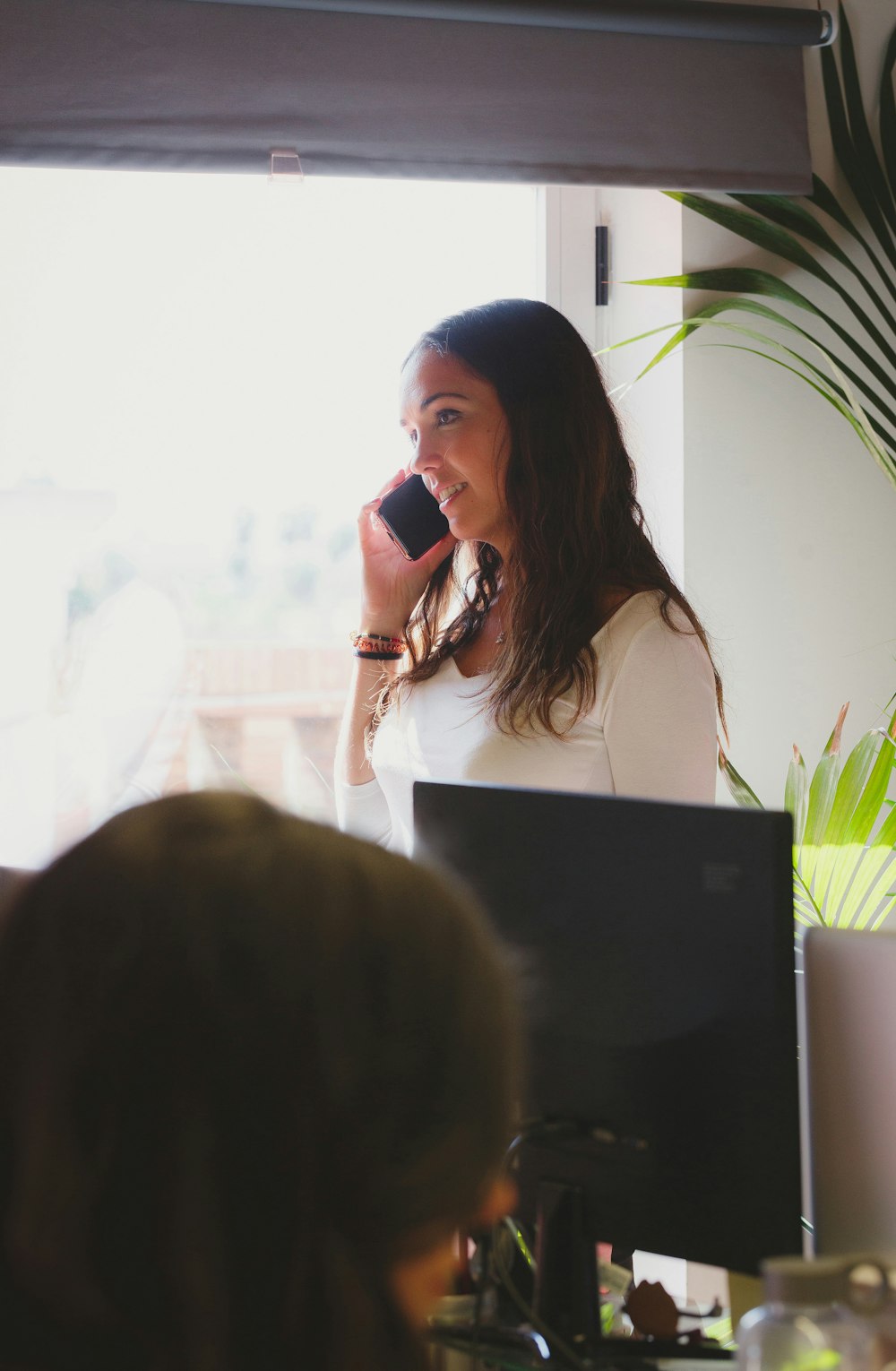 person across woman holding black smartphone