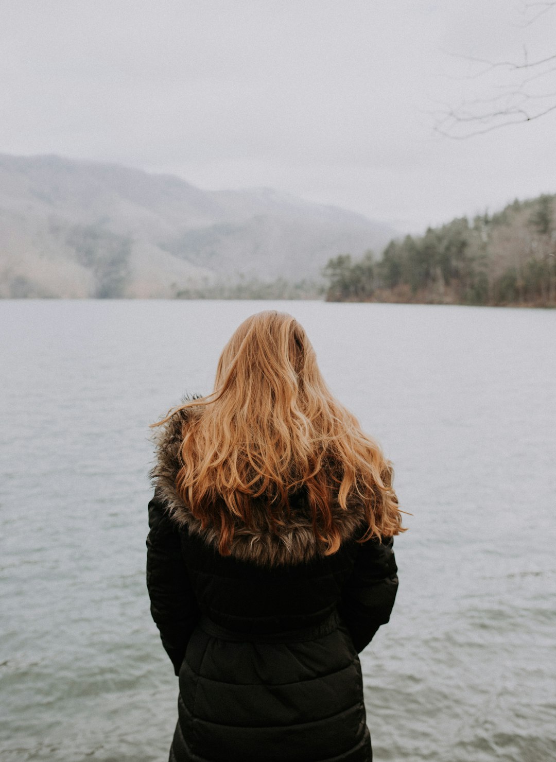 woman standing beside body of water