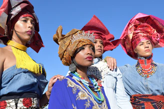 The four members of loveanh dressed in colorful traditional Vietnamese outfits with a modern twist, smiling on stage.
